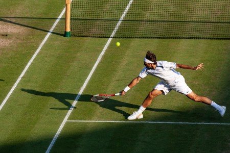 A shot of a young Roger Federer making a remarkable play, fully outstretched to the ball.