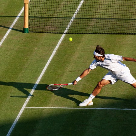 A shot of a young Roger Federer making a remarkable play, fully outstretched to the ball.