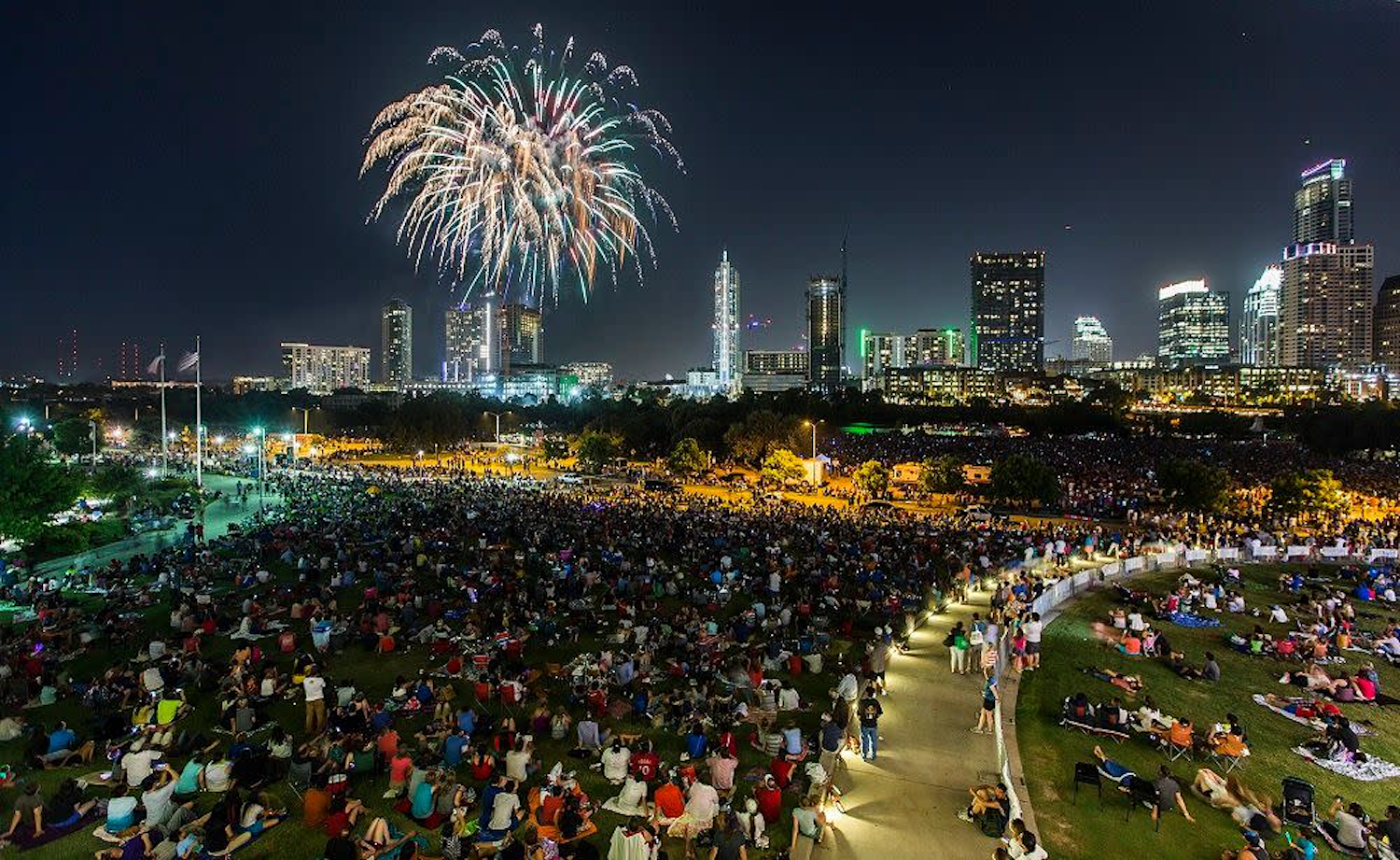 fireworks over city skyline with crowd watching best fireworks shows in texas