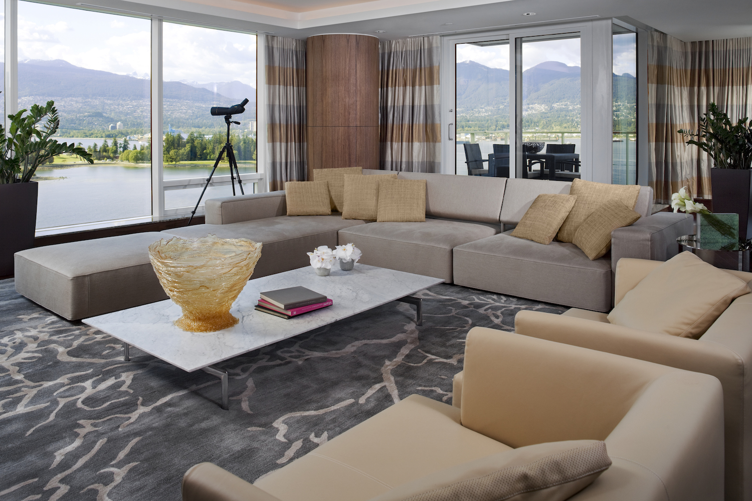 Gray couch in a living room with floor to ceiling windows with scenic view. 