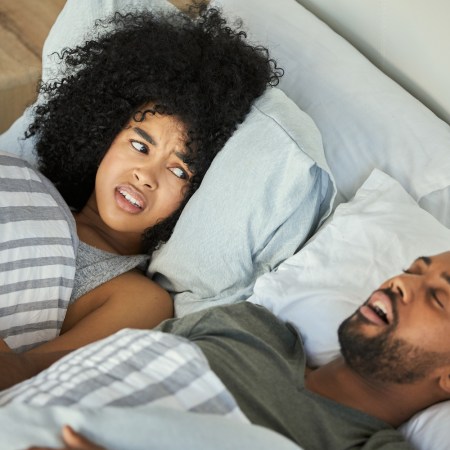 Shot of a young woman getting irritated with her husband's snoring in bed