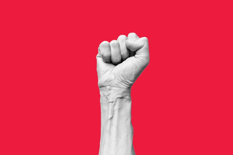 white human hand with raised fist isolated on red background