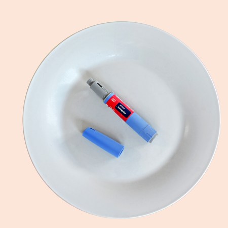 Semaglutide injecting pen with lid on a white plate