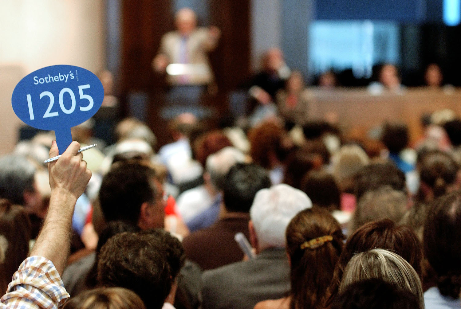 A bidder holds up his bidding sign during the Katharine Hepburn auction at Sotheby's June 10, 2004 in New York City.