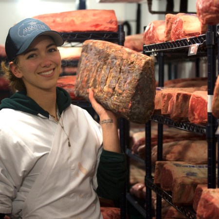 Katie Flannery posing with meat in her hand.