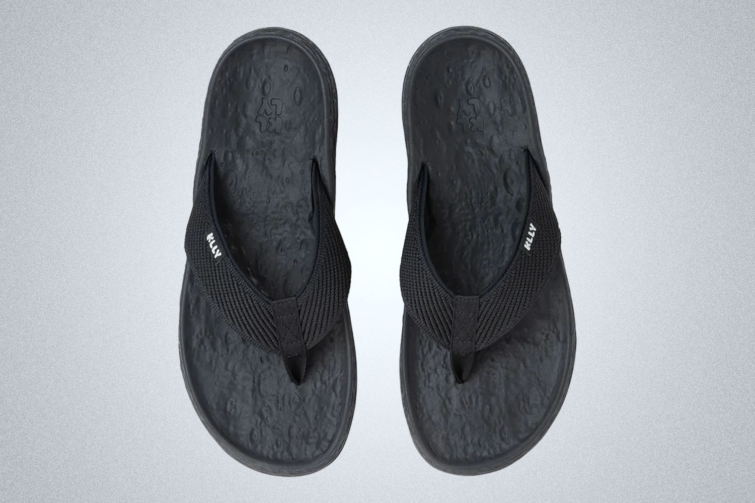 a pair of black Klly Sandals on a grey background
