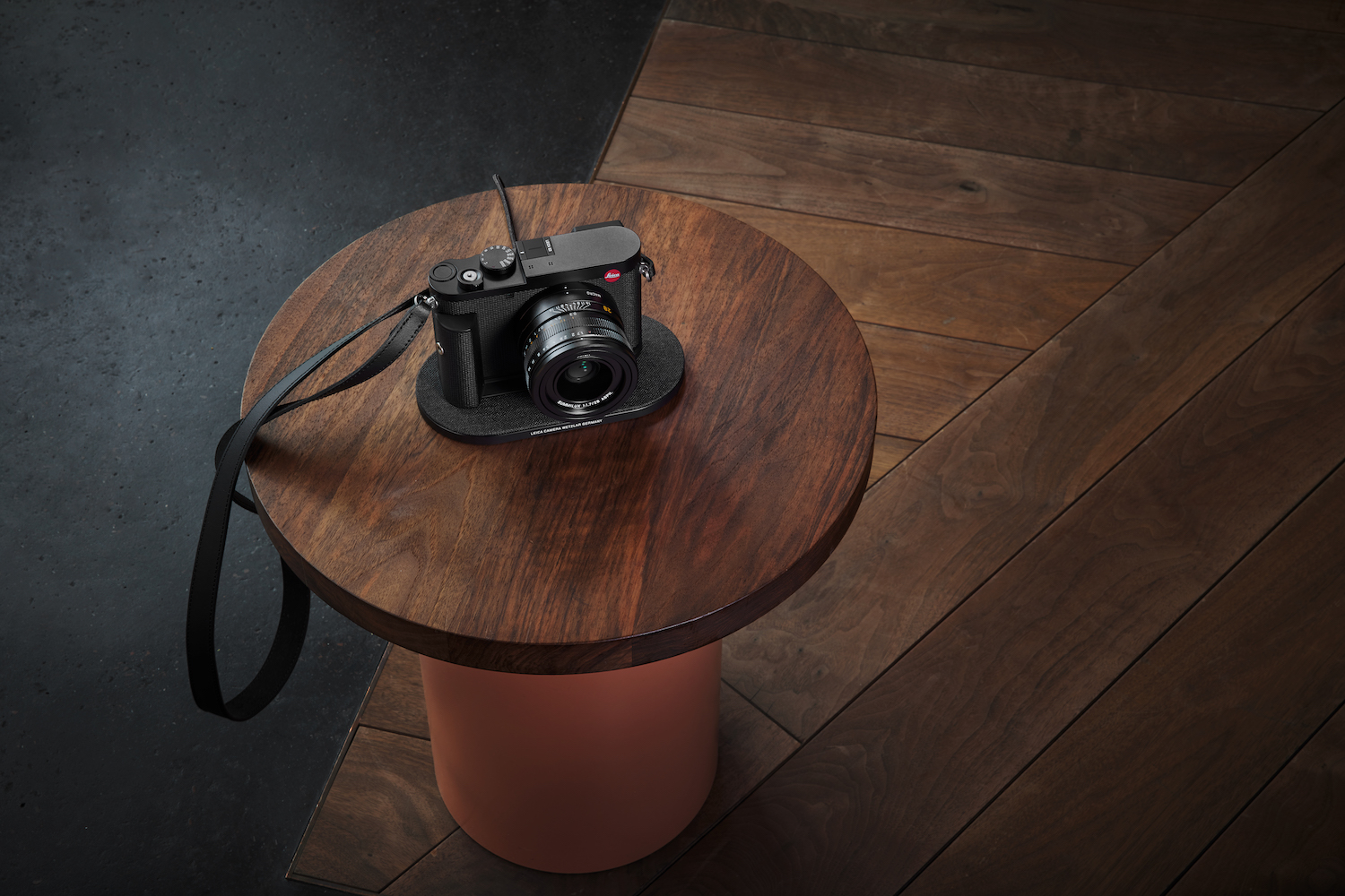 a Leica Q3 camera on a wooden stool