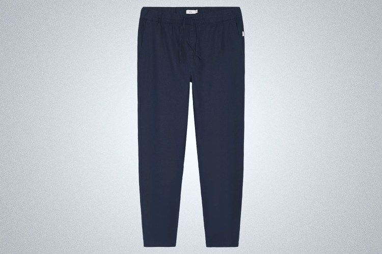 a pair of blue Onia Stretch Linen Pants on a grey background