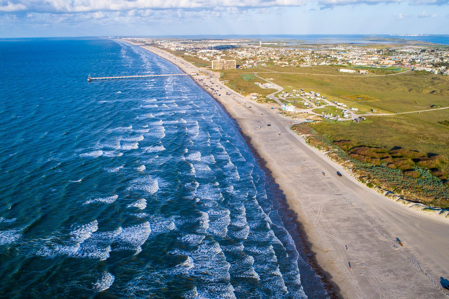 waves in ocean crashing on a beach from a birds-eye view