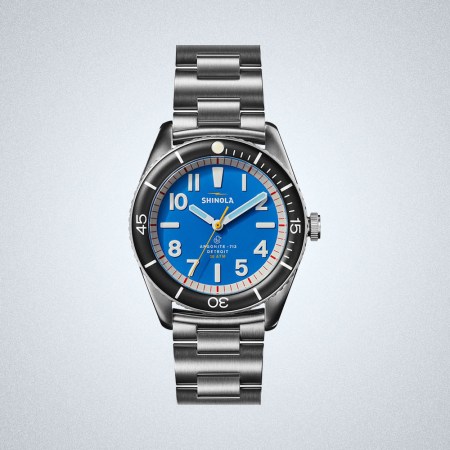 a blue-faced Shinola The Duck Bracelet Watch on a grey background