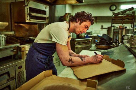 Jeremy Allen White as "Carmy" in "The Bear" writing on a box in a kitchen