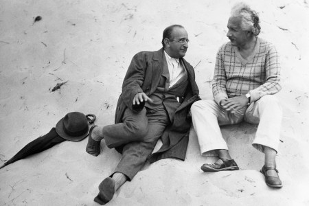 Albert Einstein sitting on a beach with his colleague.