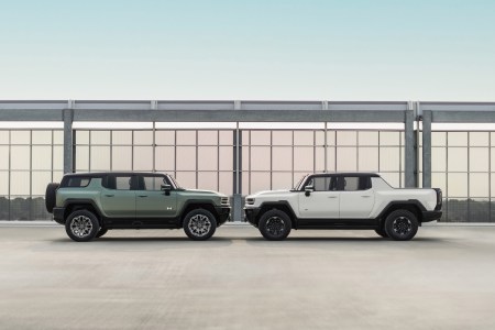 Side profile image of the 2024 GMC HUMMER EV Edition 1 SUV in Moonshot Green Matte (left) and the 2023 GMC HUMMER EV Edition 1 Pickup in Interstellar White (right).
