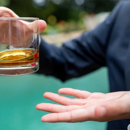 Whiskey in a glass being held by man in suit