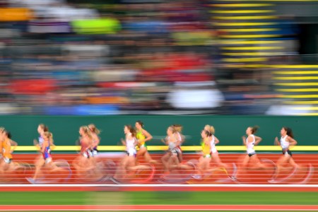 A group of elite runners on a track, in a speedy blur.