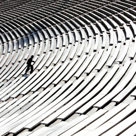 A man running up stairs in a stadium.