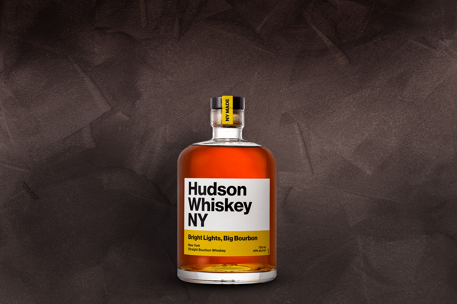 a bottle of hudson whiskey bright lights big bourbon on a grey background
