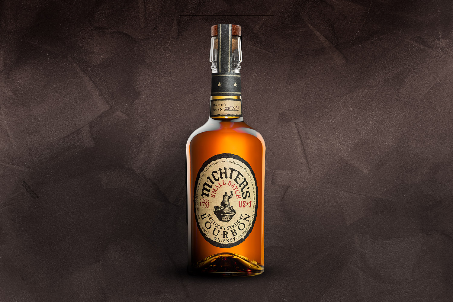 a bottle of michter's bourbon on a grey background