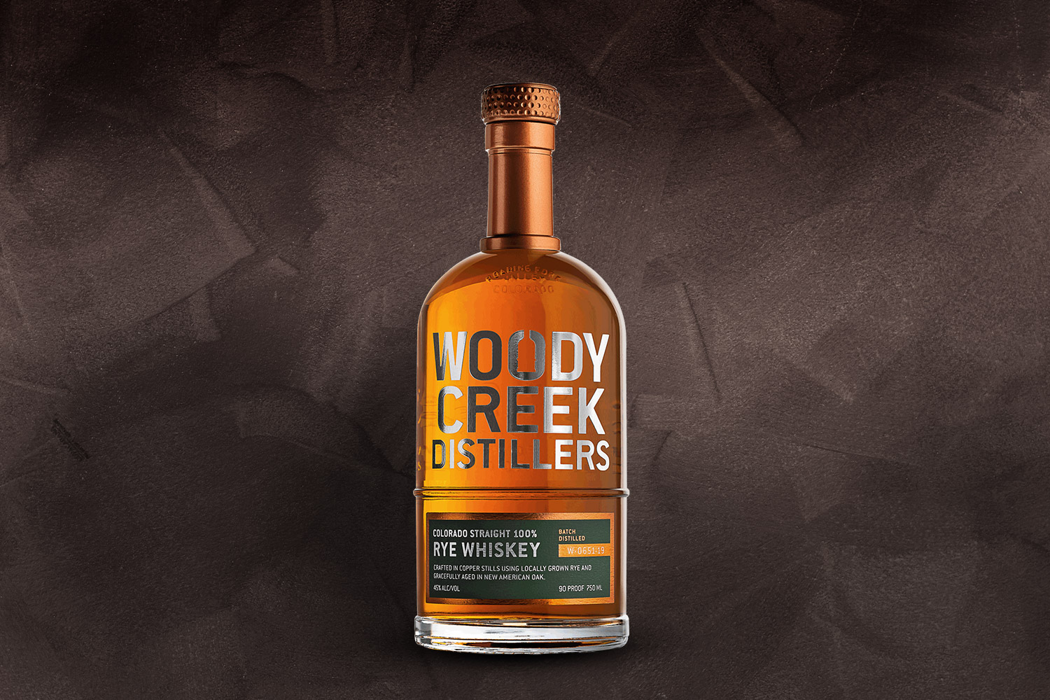 Woody Creek Distillers Colorado Bourbon on a grey background