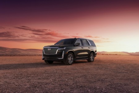A black 2023 Cadillac Escalade with a sunset behind it