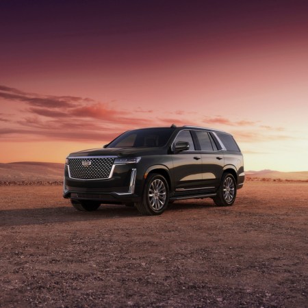 A black 2023 Cadillac Escalade with a sunset behind it