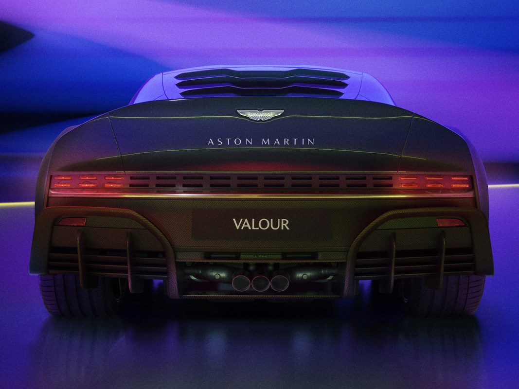 Back of a new Aston Martin car in purple lighting.