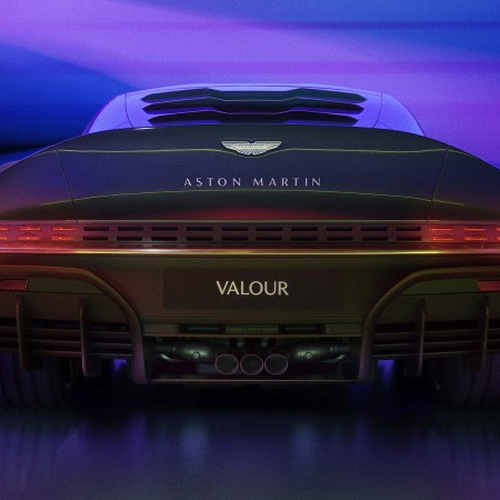 Back of a new Aston Martin car in purple lighting.