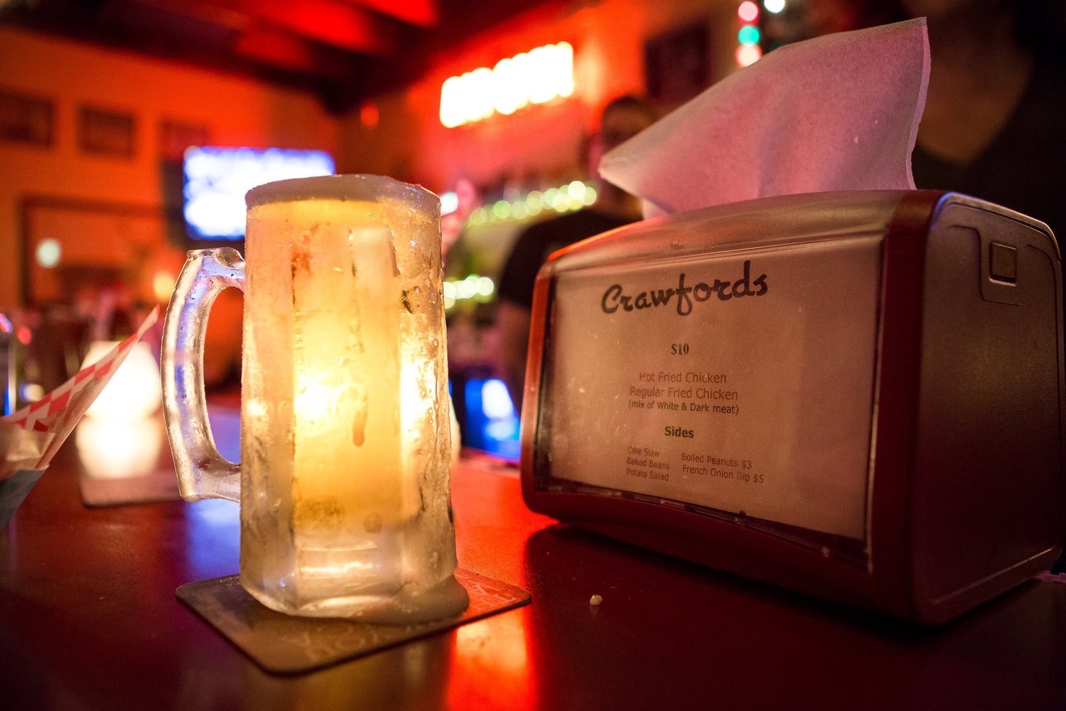 An icy beer mug on a bar.
