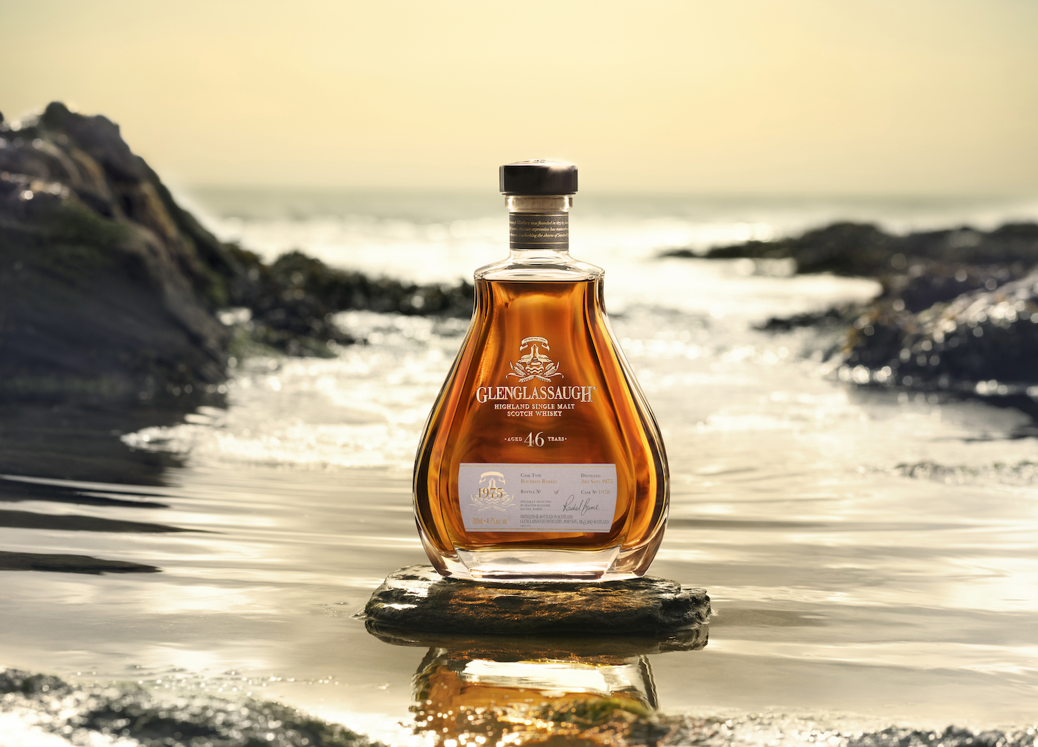 A bottle of Glenglassaugh scotch against a beach background.