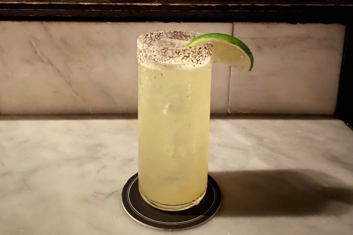 yellow highball cocktail with a salted rim