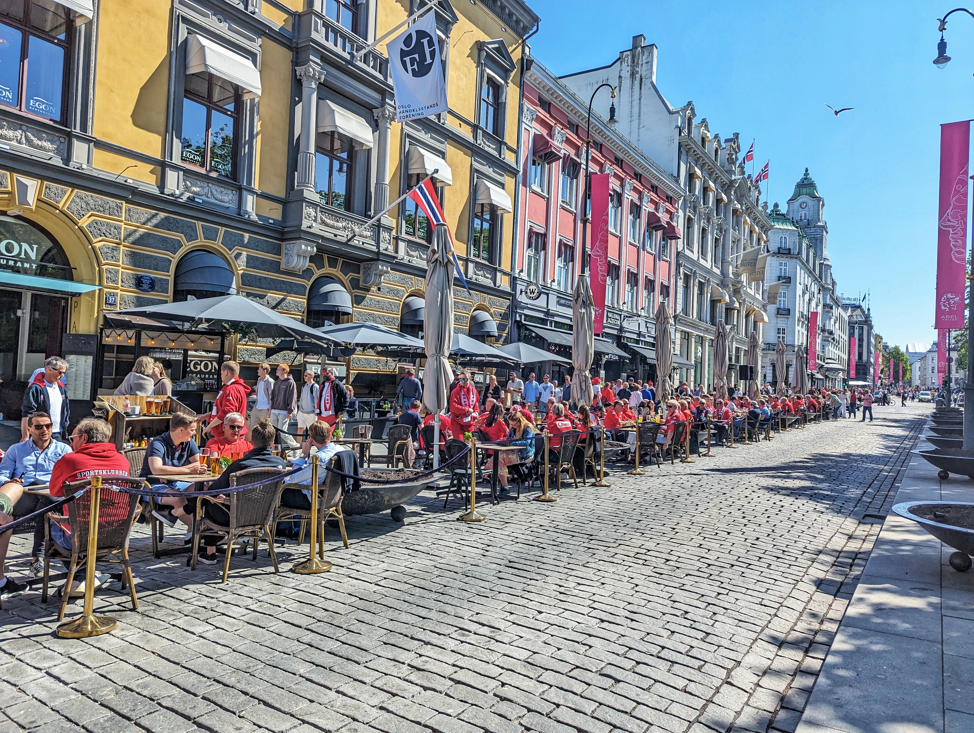Flocks of people dine outside along Karl Johans Gate, a main thoroughfare in Oslo, Norway