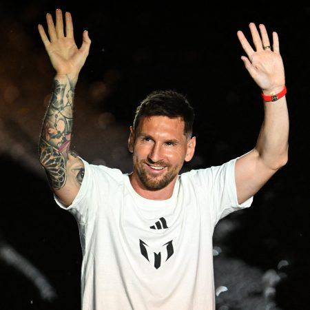 Lionel Messi waves as he is presented as the newest MLS player.