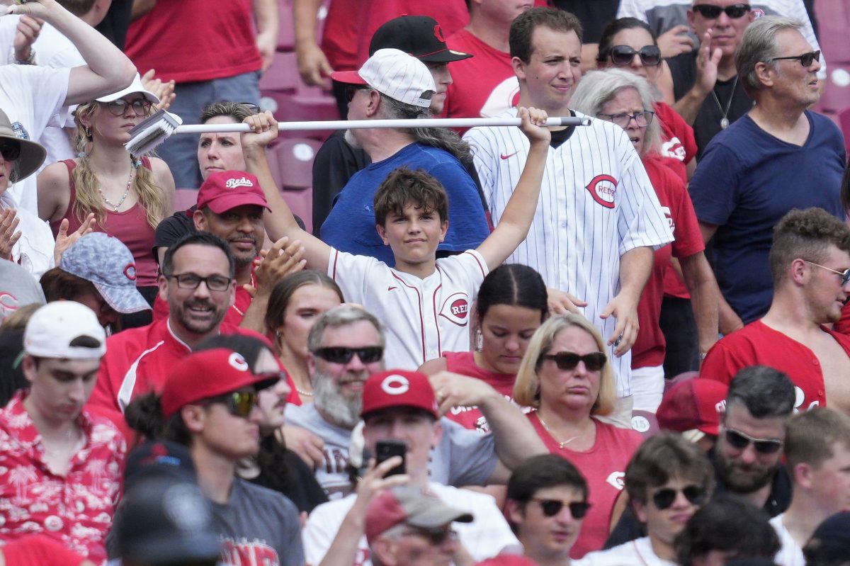 A young fan holds up a broom during a game.