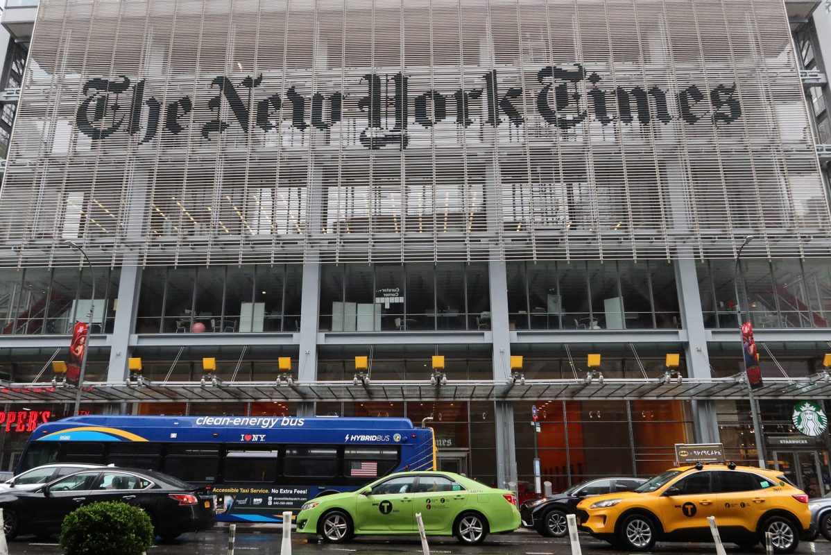 Taxis drive past the front of the New York Times building.