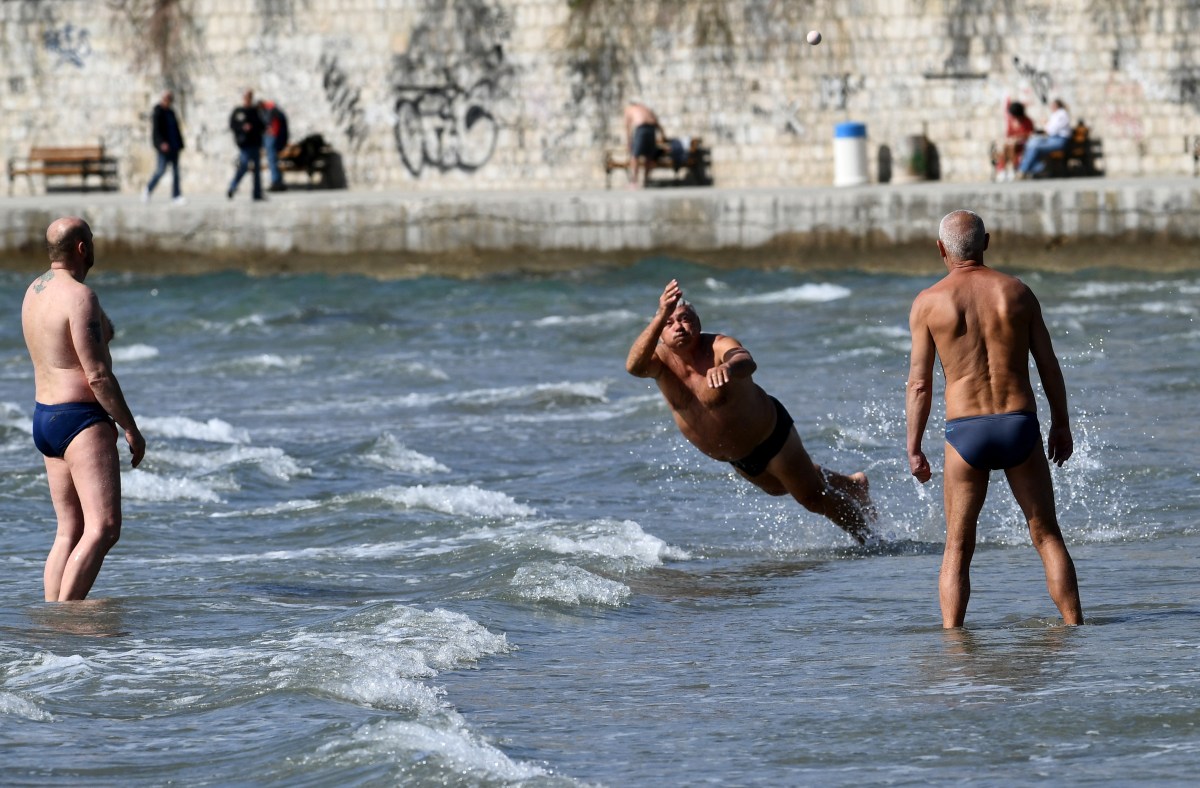 A group of men play a game called "Picigin" on Bacvice Beach along the Croatian coastline.