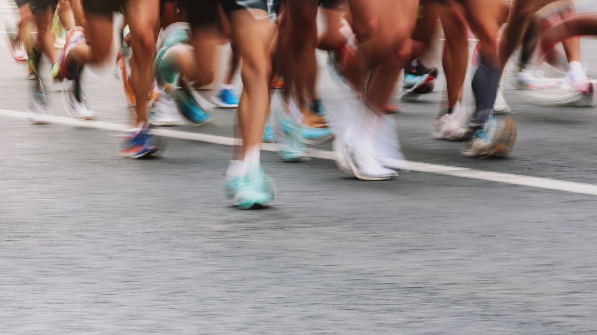 An artistically blurry photo of runners' legs zooming by in a race.