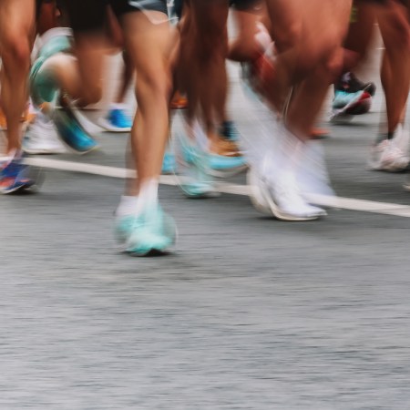 An artistically blurry photo of runners' legs zooming by in a race.