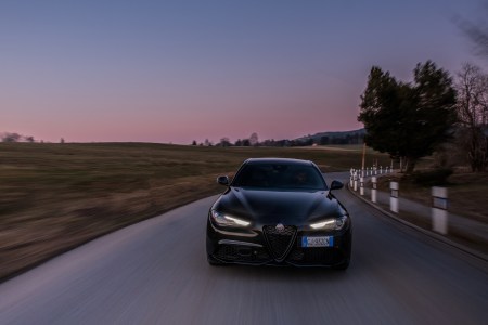 Alfa Romeo model driving on road during sunset