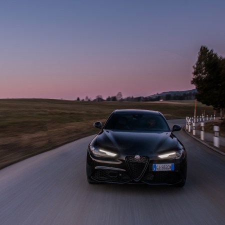 Alfa Romeo model driving on road during sunset