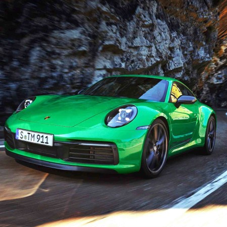 The 2023 Porsche 911 Carrera T in green driving up a mountain road
