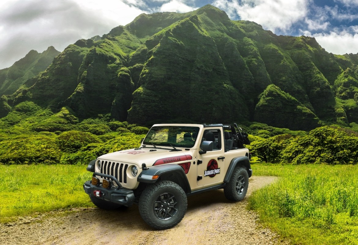 Jeep with graphics in grassy landscape.