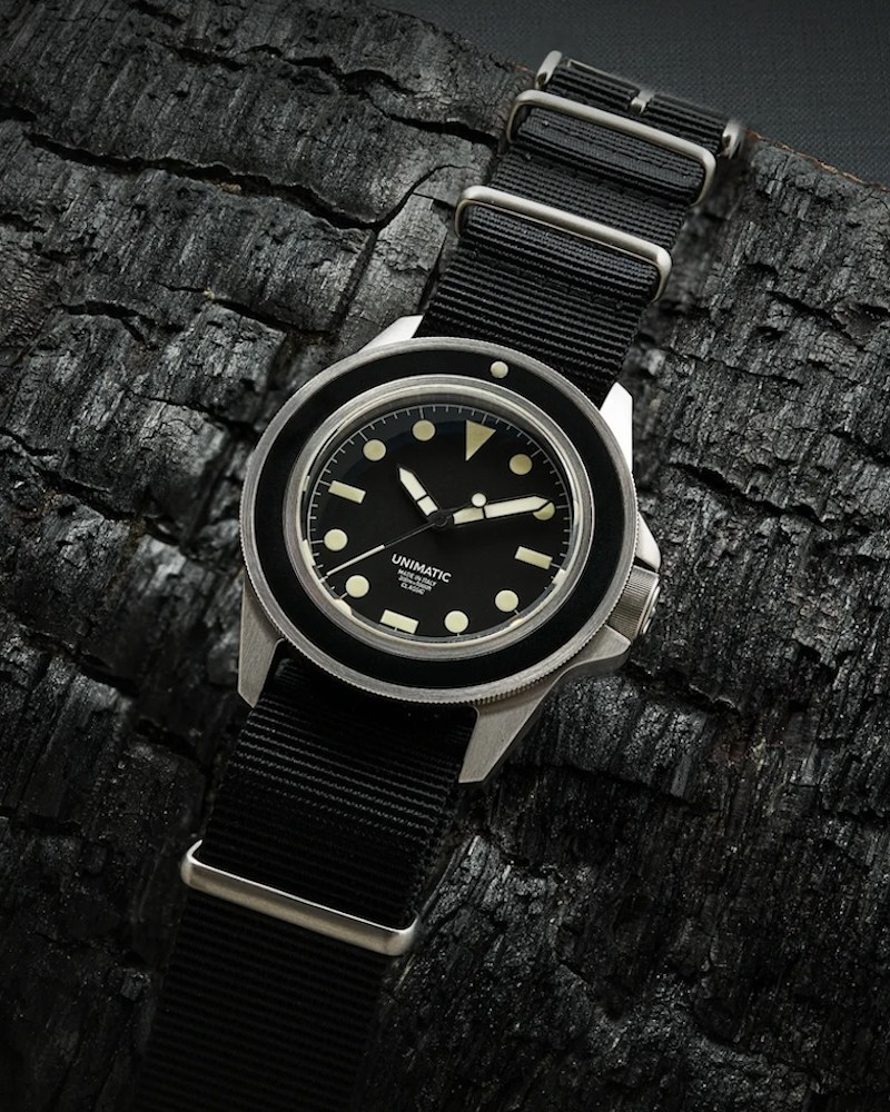 A Unimatic watch on a black background