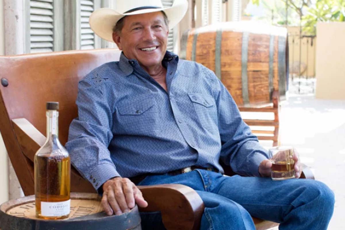 George Strait sitting next to a bottle of Codigo 1530 tequila, where he's a partner