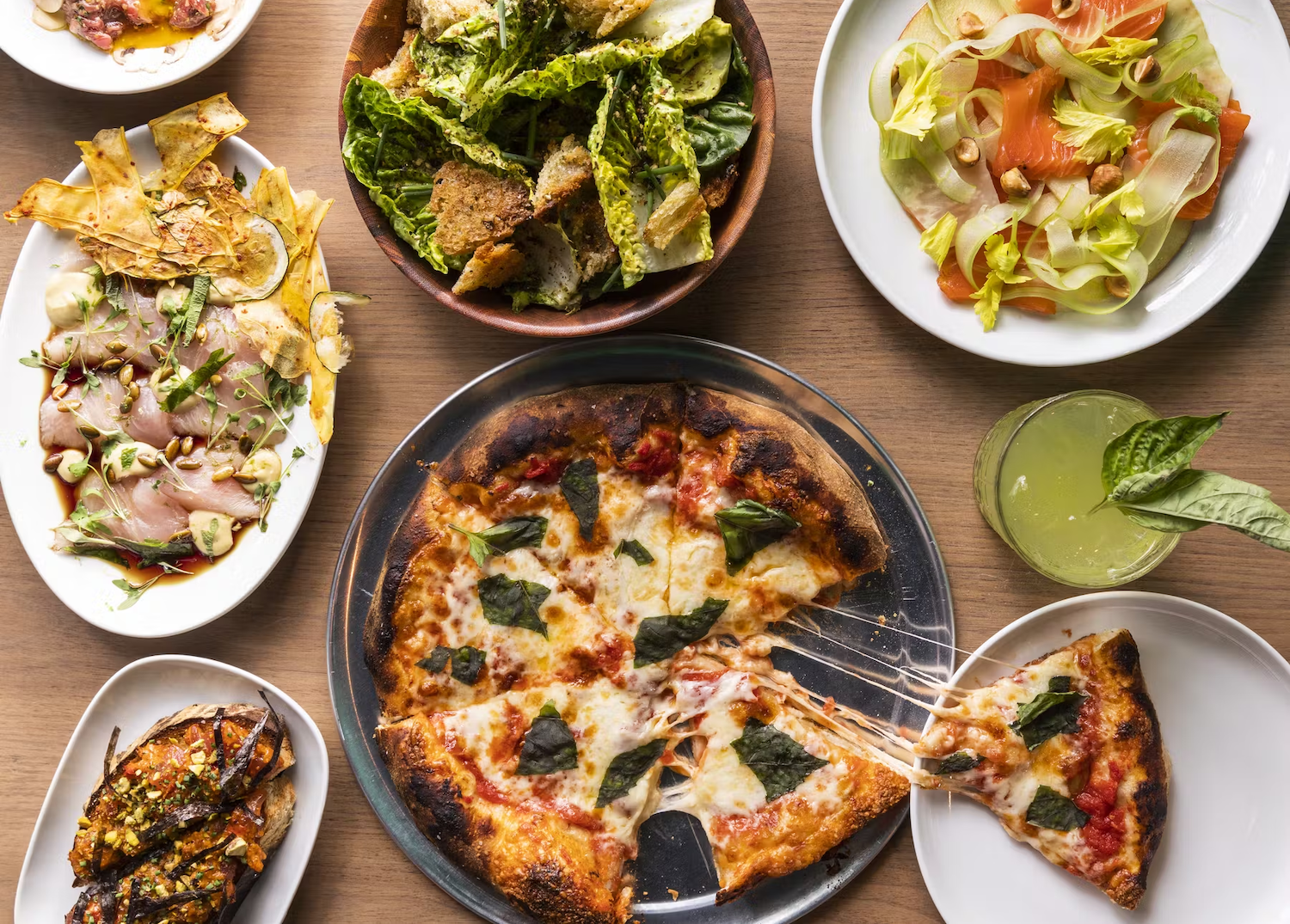 Spread of pizza and other dishes on a table