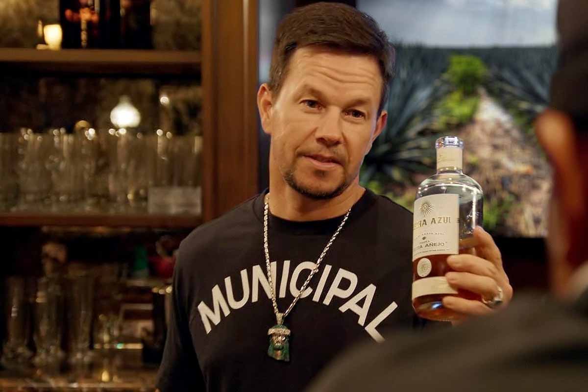 Co-owner Mark Wahlberg holding a bottle of Flecha Azul tequila