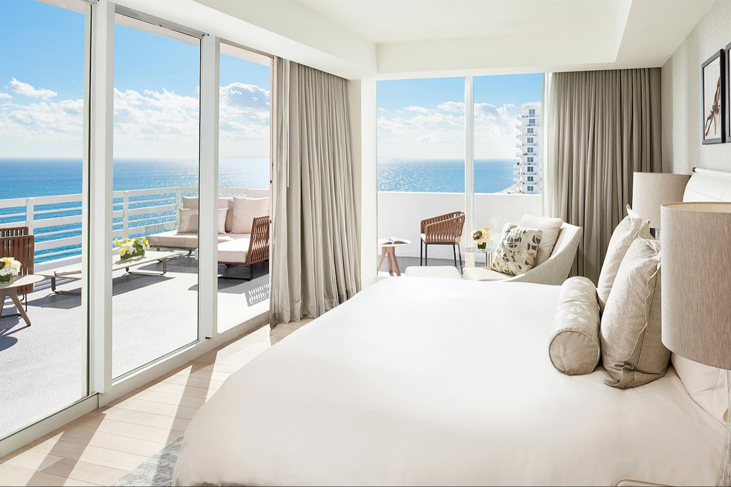 Hotel room overlooking the ocean through floor-to-ceiling windows