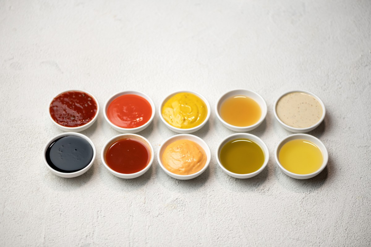 Big Set of colored sauces in Crockery. Different sauces, mayonnaise, mustard, soy sauce, oil and ketchup on white background.