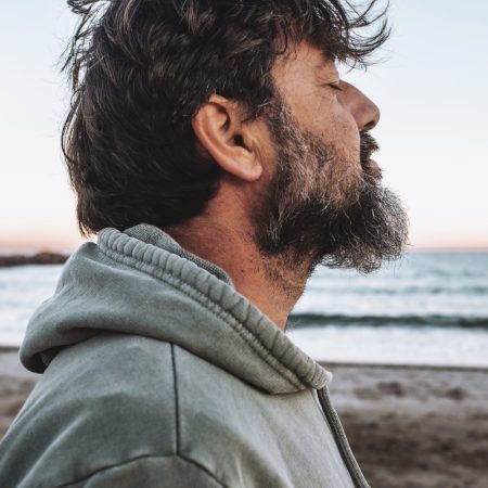 Mature man with eyes closed at beach