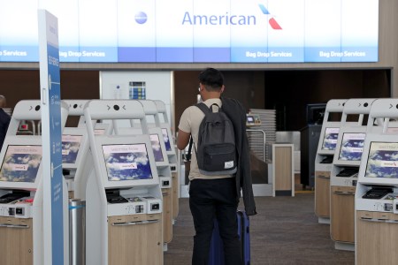 a person with a backpack at the american airlines check in kiosks at the airport