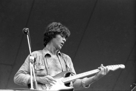 Robbie Robertson plays his Fender Stratocaster electric guitar as he performs outside onstage in June 1976.
